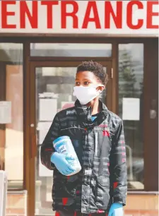  ?? JULIE OLIVER ?? Twelve-year-old Cruz Fede waits with his mom to be seen at the clinic for a rash. He came prepared with a mask, gloves and wipes.