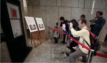  ??  ?? Visitors take pictures of a piece of graffiti believed to be the work of British street artist Banksy, at the Tokyo Metropolit­an Government building in Tokyo. — AFP photo