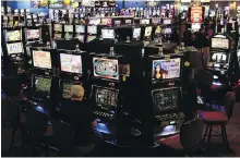  ??  ?? A man plays slot machines at the View Royal Casino.