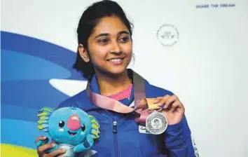  ?? AFP ?? Silver medallist Mehuli Ghosh poses on the podium at the awards ceremony after the women’s 10-metre air rifle shooting final at the Belmont Shooting Complex.