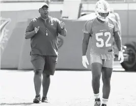  ?? LYNNE SLADKY/AP ?? Dolphins defensive coordinato­r Patrick Graham, left, talks with middle linebacker Raekwon McMillan during training camp in Davie.