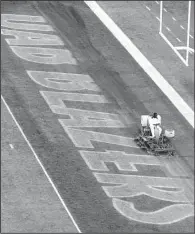  ?? AP/Al.com/MARK ALMOND ?? A worker erases the “UAB Blazers” logo from the end zone after Alabama-Birmingham’s final home game of the season Nov. 22 at Legion Field in Birmingham, Ala. The school announced Tuesday that it was eliminatin­g football.