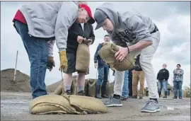  ?? Jesse Tinsley Spokane Spokesman-Review ?? RESIDENTS stack sandbags at a class in Usk, Wash. Gov. Jay Inslee has mobilized to coordinate resources to deal with f looding in the eastern part of the state.