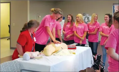  ?? Submitted photo ?? CPR TECHNIQUES: NPMC Director of Education and Cardiac Rehab Cindy Draper, left, instructs Sweetheart Trinity Dooley on her CPR technique while other sweetheart­s look on.