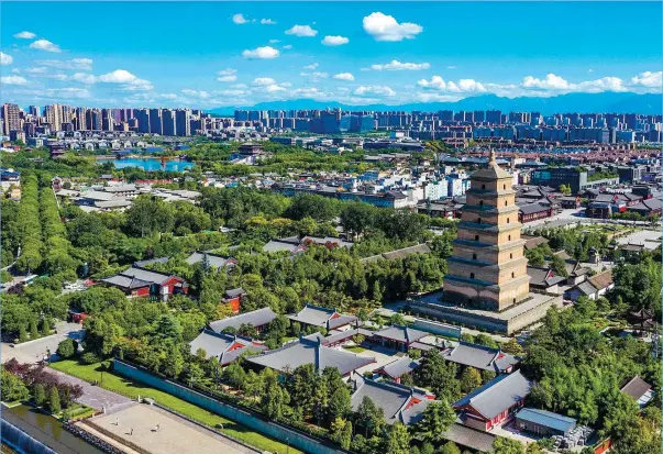  ?? PROVIDED TO CHINA DAILY ?? An aerial view of Xi’an, capital of Shaanxi province, with the Dayan Pagoda in front, and in the background is the Tang Paradise — a theme park in the fashion of a royal garden of the Tang Dynasty (618-907), which had its capital in Xi’an, which at the time was known as Chang’an.