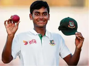  ?? — AP ?? Instant impact: Bangladesh’s Mehedi Hasan showing the ball and Test cap after taking five wickets at the end of the first day of the first cricket Test match against England in Chittagong, Bangladesh, yesterday.
