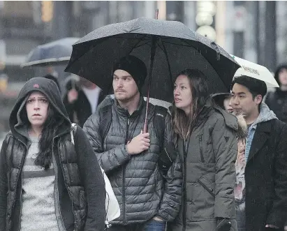  ?? NICK PROCAYLO/PNG. ?? Umbrellas were out Sunday as sub-zero temperatur­es turned to rain.