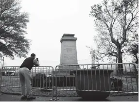  ??  ?? Memphian Brett Schutt takes a picture of the removed statue of Confederat­e President Jefferson Davis in Fourth Bluff Park Thursday morning. The city of Memphis sold two public parks containing Confederat­e monuments to a nonprofit Wednesday in a massive, months-in-the-planning operation to take the statues down overnight. MARK WEBER/THE COMMERCIAL APPEAL