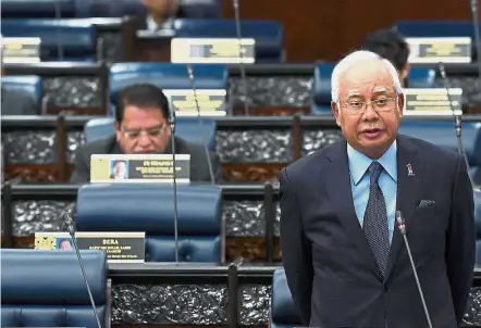  ??  ?? Calm and relaxed: Najib addressing questions and doubts over his US trip at the Dewan Rakyat. — Bernama