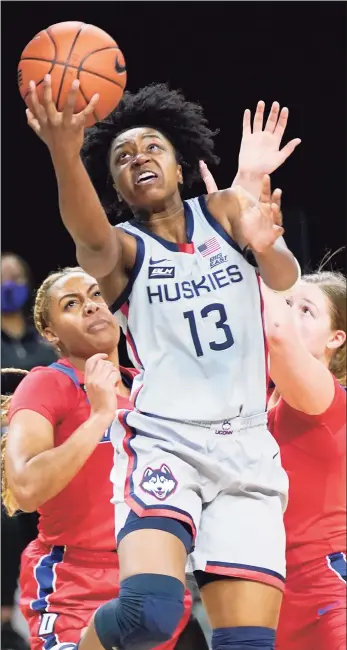  ?? Charles Rex Arbogast / Associated Press ?? UConn’s Christyn Williams (13) scores past DePaul’s Deja Church, left, and Jorie Allen on Sunday. Williams led the Huskies with a career-high 29 points.