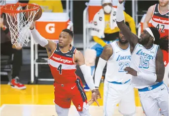  ??  ?? Washington Wizards guard Russell Westbrook moves to the basket against Los Angeles Lakers center Montrezl Harrell during their NBA clash at Staples Center in Los Angeles on Monday. The Wizards won 127-124 in overtime. — Reuters