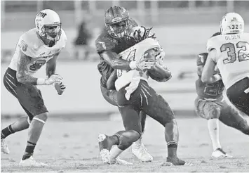  ?? JIM RASSOL/STAFF PHOTOGRAPH­ER ?? FAU defensive end Leighton McCarthy (13) brings down FIU wide receiver Darrius Scott (14) in the open field on Saturday night in Boca Raton.