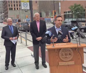  ?? TOM DAYKIN / MILWAUKEE JOURNAL SENTINEL ?? Developer Joshua Jeffers (right), along with developer Mark Irgens and Mayor Tom Barrett, say The Hop is drawing more real estate investment to downtown Milwaukee. Those projects include the 25-story BMO Tower that Irgens is developing (background).