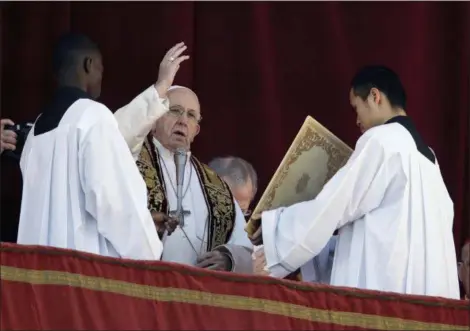  ?? ALESSANDRA TARANTINO — THE ASSOCIATED PRESS ?? Pope Francis delivers Tuesday the Urbi et Orbi (Latin for ‘to the city and to the world’) Christmas’ day blessing from the main balcony of St. Peter’s Basilica at the Vatican.