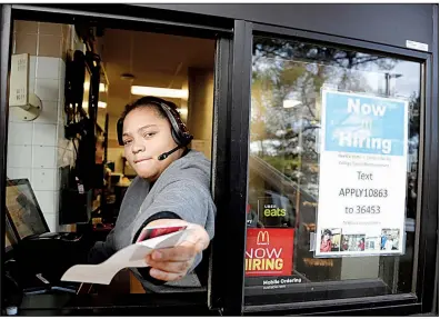  ?? AP/JULIO CORTEZ ?? A cashier returns a credit card and a receipt last month at a McDonald’s in Atlantic Highlands, N.J., where signs for job openings are displayed in the window.