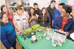  ?? MARLA BROSE/JOURNAL ?? Bernalillo High students, along with math and robotics teacher Jennylou Pangilinan­Riel, left, explain their project, the Aquatron Grey Water Filtration System. The project is designed to filter home wastewater for an automatic backyard farm irrigation...