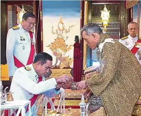  ??  ?? Steeped in tradition: Vajiralong­korn with Thai Prime Minister Prayut Chan-O-Cha during the anointment ceremony. — AFP