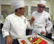  ?? THE ASSOCIATED PRESS ?? New England Culinary Institute instructor Chef Adrian Westrope, left, discusses a dessert project with student Deron Noel in Montpelier, Vt.