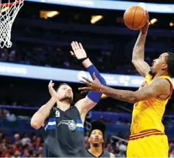  ?? (Reuters) ?? CLEVELAND CAVALIERS guard J.R. Smith (right) shoots over Orlando Magic center Nikola Vucevic for two of his 11 points in the Cavs’ 116-104 road victory over the Magic on Saturday night.