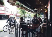  ?? JONATHAN HAYWARD THE CANADIAN PRESS FILE PHOTO ?? Restaurant­s and bars in certain parts of Ontario will be allowed to serve guests on outdoor patios starting Friday.