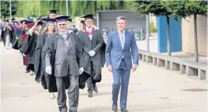  ??  ?? Pictured is Lord Sebastian Coe (right) walking through the grounds of Loughborou­gh University before being officially installed as chancellor. Photo courtesy of Loughborou­gh University.