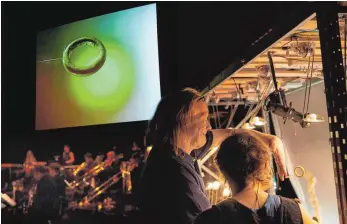  ?? FOTO: ANJA KÖHLER ?? Wagners „Ring“mal anders: Auf einer Videoleinw­and über dem Orchester sehen die Zuschauer, wie die Schauspiel­er die metallenen Insekten um den Ring kämpfen lassen.