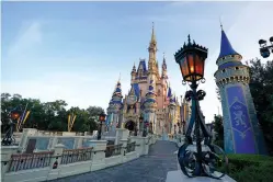  ?? AP Photo/John Raoux, File ?? ■ The newly painted Cinderella Castle at the Magic Kingdom at Walt Disney World is seen with the the crest to celebrate the 50th anniversar­y of the theme park on Aug. 30, 2021, in Lake Buena Vista, Fla.