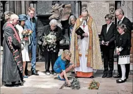  ?? BEN STANSALL/GETTY ?? Lucy Hawking, the daughter of Stephen Hawking, places flowers at the site where his ashes were interred Friday in London’s Westminste­r Abbey during a memorial service. The scientist, whose book “A Brief History of Time” sold 9 million copies, died in...