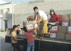  ??  ?? Yemenis with food boxes from the UAE Red Crescent in Marib city in 2015, but the war has reduced Yemen’s ability to distribute aid