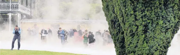  ?? PHOTOS: STEPHEN JAQUIERY ?? There she blows . . . Guests at Mike Hunter’s retirement function at Larnach Castle on Thursday have their finery rearranged after the guest of honour arrived in an Otago Regional Rescue helicopter.