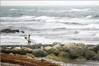  ?? MEGHAN MCCARTHY / THE PALM BEACH POST ?? Near Midtown Beach in Palm Beach on Labor Day, a surfer takes advantage of the watery unrest kicked up by Tropical Storm Gordon to go in search of the perfect wave.