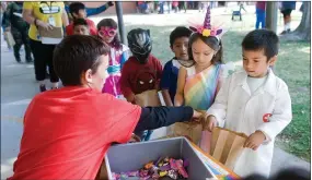  ?? RECORDER PHOTO BY CHIEKO HARA ?? Trick-or-treaters visit stations to get candy after their Halloween costume parade Wednesday, Oct. 31 at Alta Vista Elementary School.