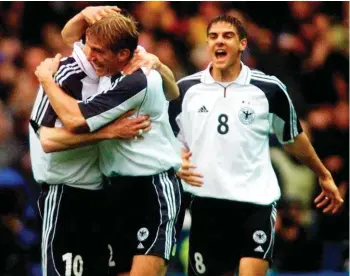  ??  ?? In this Oct. 7, 2000 file photo Germany's Dietmar Hamann, left, is embraced by teammate Marko Rehmer, center, while Sebatian Deisler celebrates after the opening goal during the group nine World Cup qualificat­ion match England versus Germany at Wembley stadium in London. The last game at the old Wembley turned out to be Kevin Keegan's last game in charge of England's national team. The coach decided to quit while seeking privacy in a bathroom cubicle shortly after Dietmar Hamann's free kick squirmed through the hands of goalkeeper David Seaman. (AP Photo/Christof Stache, File)