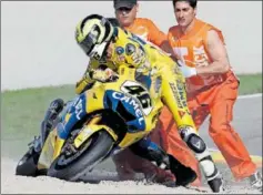  ?? ?? Rossi trata de levantar la moto tras su caída en Valencia 2006.