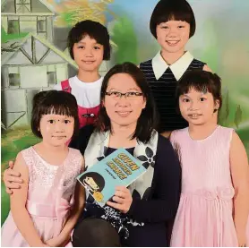  ??  ?? Prof Gan with her treasures – her four children ( and her first collection of stories!). She loved last year’s workshop so much, she’s going again this year, and taking one of her daughters along. — Handout