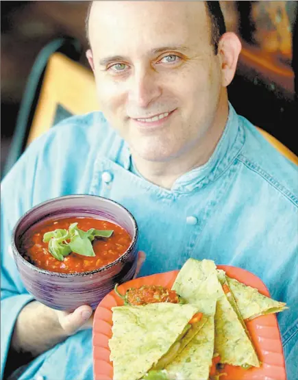  ?? TAIMY ALVAREZ / SOUTH FLORIDA SUN- SENTINEL ?? Chef Steve Petusevsky holds his tomatillo quesadilla­s with pinto beans, green chilies and potatoes with a side of salsa verde with avocado.