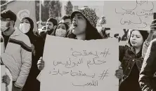  ?? Houssem Zouari / AFP / Getty Images ?? Tunisian protesters lift placards and chant during an anti-government demonstrat­ion in the coastal city of Sfax.