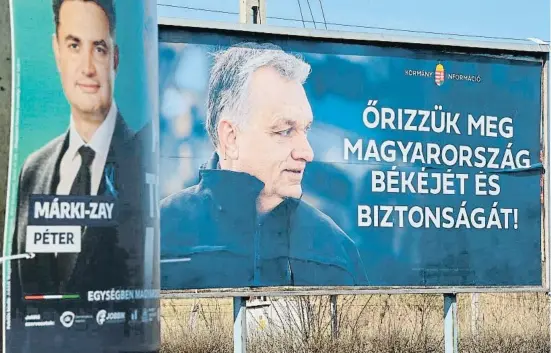  ?? ATTILA  ISBENEDE  / AFP ?? Un cartell electoral de l’opositor Márki-Zay al costat d’un missatge del Govern amb la foto d’Orbán, a Kisvárda, ciutat de l’est del país