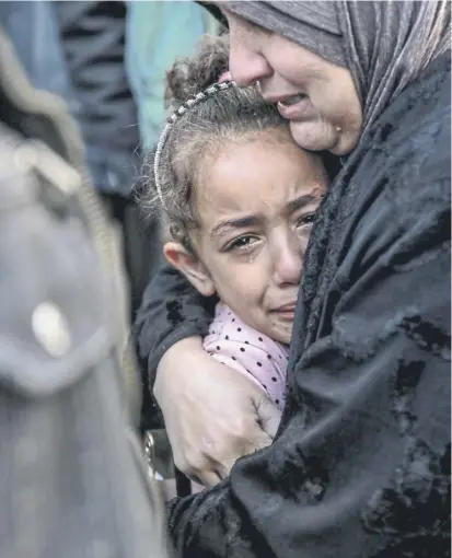  ?? PICTURE: AFP VIA GETTY IMAGES ?? A Palestinia­n woman holds a child as they mourn relatives killed in an Israeli bombardmen­t in Gaza City last month