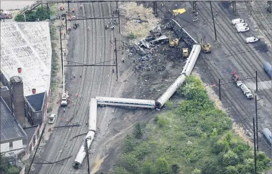  ?? Patrick Semansky Associated Press ?? EMERGENCY CREWS work at the site of the derailment in Philadelph­ia. Among scores of people hurt, eight were in critical condition; many others had rib injuries.