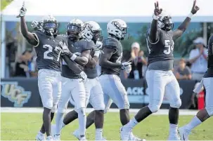  ?? STEPHEN M. DOWELL/ORLANDO SENTINEL ?? UCF defensive back Richie Grant (27) celebrates with teammates after making an intercepti­on. The Knights have given up a lot of yards, but they adjust well during games.