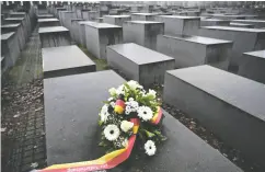  ?? JOHN MACDOUGALL / AFP VIA GETTY IMAGES FILES ?? Flowers are shown at Berlin’s Holocaust memorial. Germany has proposed adding questions about
antisemiti­sm to its citizenshi­p test.