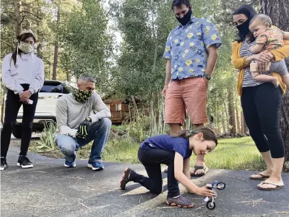  ?? PETER ORSI AP ?? Vivian Filipic plays with a toy motorcycle in Truckee, Calif., on June 19, the day before her 5th birthday. From left, Scarlett Fierro, Craig Fierro, Vivian’s parents Filip Filipic and Kirsten Mickelson, and her brother Luca Filipic, 9 months, look on. Fierro has brought toys to local kids.