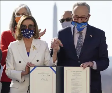  ?? ALEX BRANDON—ASSOCIATED PRESS ?? House Speaker Nancy Pelosi of Calif., and Senate Majority Leader Chuck Schumer of N.Y., pose after signing the $1.9 trillion COVID-19 relief bill during an enrollment ceremony on Capitol Hill, Wednesday, March 10, 2021, in Washington.