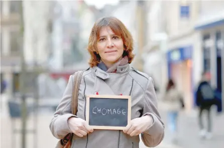  ?? — Reuters ?? Nathalie Reperant, an insurance company employee, holds a blackboard with the word “chomage” (unemployme­nt) in Chartres, France.