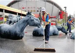  ?? Jeff McIntosh/THE CANADIAN PRESS ?? Cleanup crews tackle the Calgary Stampede grounds on Monday, The 10-day extravagan­za is scheduled to open on July 5.