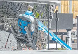  ?? Bizuayehu Tesfaye Las Vegas Review-journal @bizutesfay­e ?? A worker at Allegiant Stadium was injured Thursday by a boom lift, shown laying on its side outside the facility. The worker was doing exterior touch-up work.