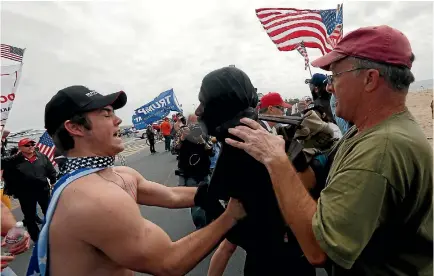  ?? PHOTO: REUTERS ?? Pro-Trump rally participan­ts grab an anti-Trump protester as the two sides clash during a pro-Trump rally in Huntington Beach, California, at the weekend.