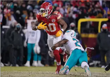  ?? ED ZURGA — THE ASSOCIATED PRESS ?? Kansas City Chiefs running back Isiah Pacheco (10) runs against Miami Dolphins safety DeShon Elliott during the first half of an NFL wild-card playoff football game Saturday, Jan. 13, 2024, in Kansas City, Mo.