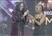  ?? CHRIS PIZZELLO — THE ASSOCIATED PRESS ?? H.E.R., left, and Tiara Thomas accept the 2021 Grammy for song of the year for “I Can’t Breathe” on March 14.